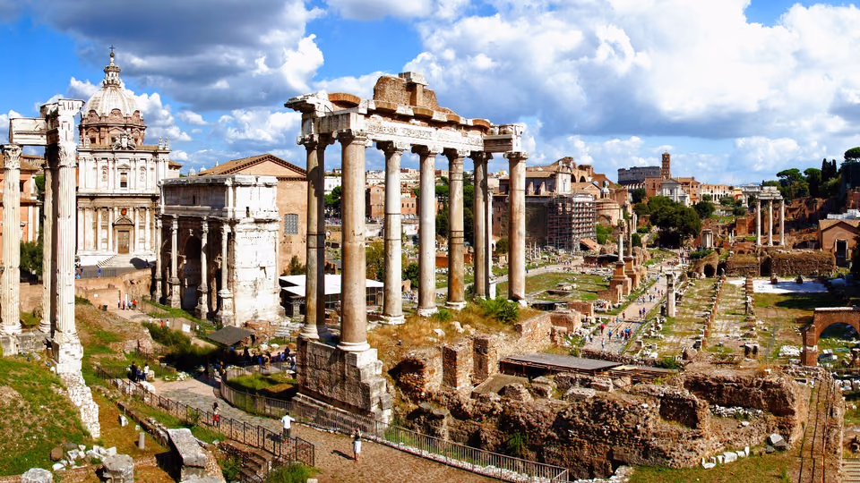Säulen und Ruinen des Forum Romanum unter blauem Himmel mit Wolken