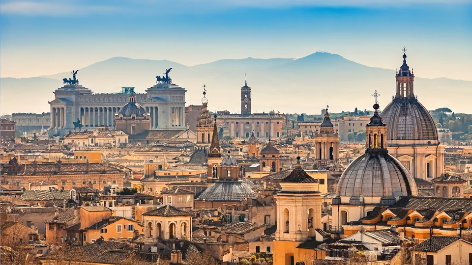 Dächer und Kuppeln der Altstadt von Rom mit dem Nationaldenkmal Vittoriano im Hintergrund
